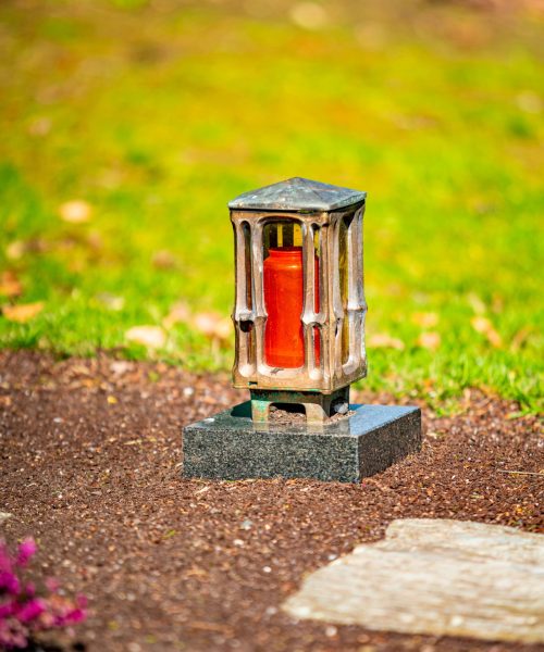grave-light-with-candle-on-a-grave-with-flowers-2025-01-08-11-35-33-utc-min